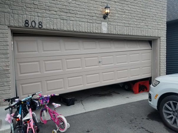 A garage door in Manotick that is out of tracks. 
